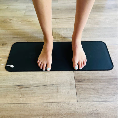 office worker with feet standing on grounding mat